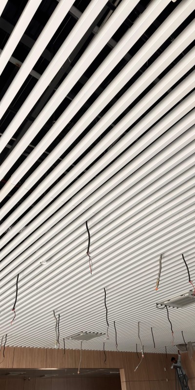 U-shaped baffle ceiling installed in commercial atrium — Yashvi Infra Co Ahmedabad Gujarat