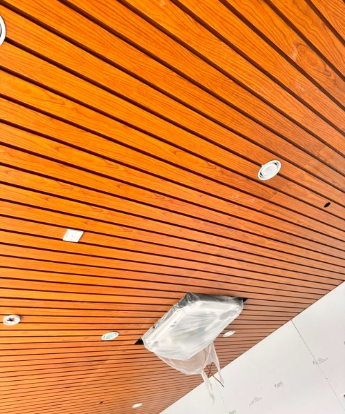 Wood grain metal ceiling installation Adani Airport — Yashvi Infra Co